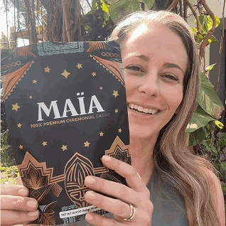 Person holding a Maia ceremonial cacao package outdoors.